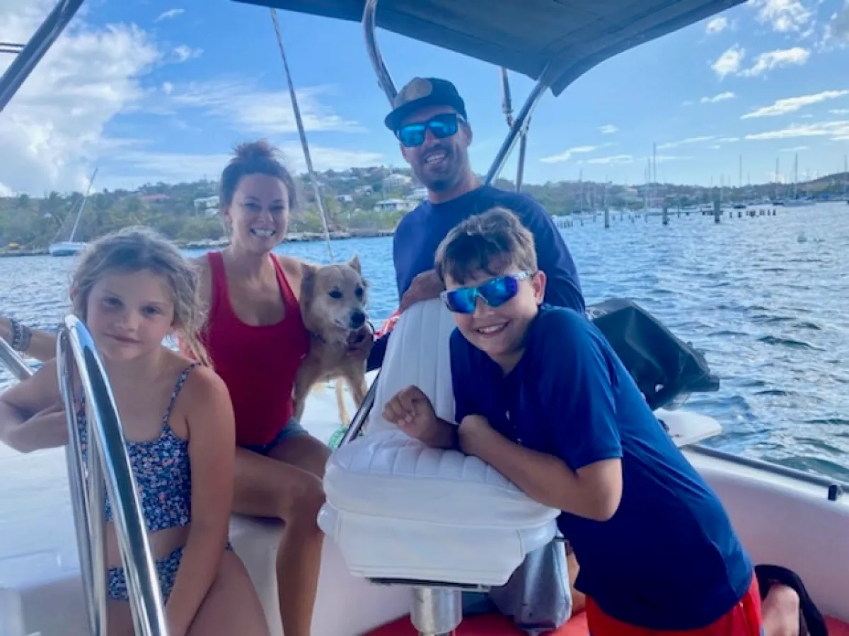 a person standing in front of a boat next to a body of water