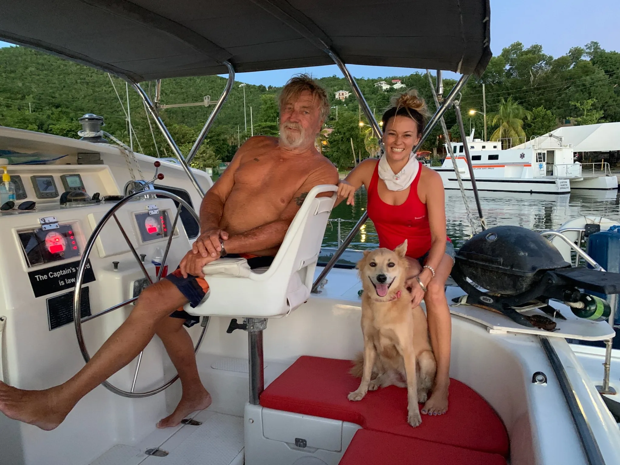 a man and a woman sitting on a boat with a dog